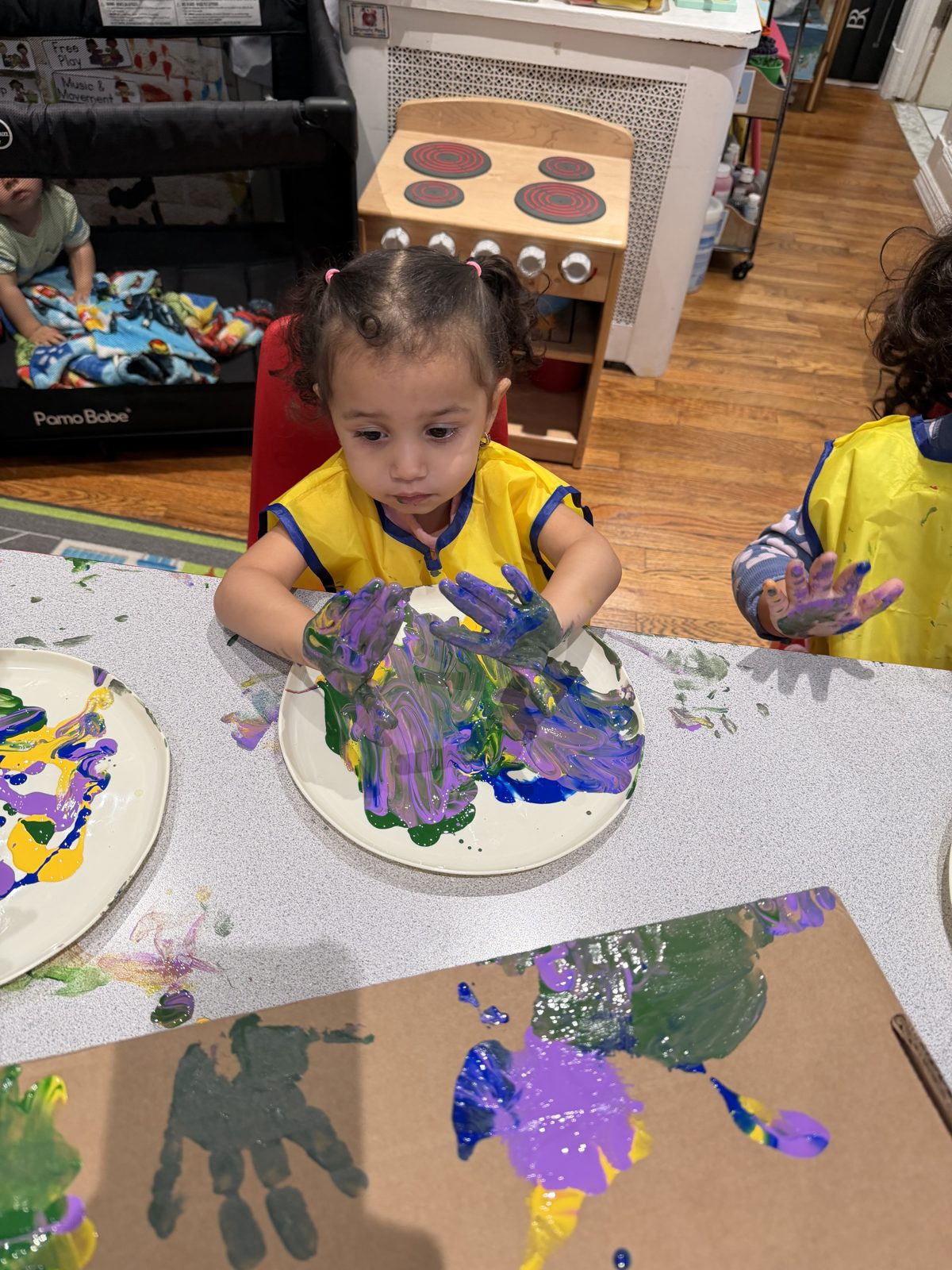 Child finger painting at the art table